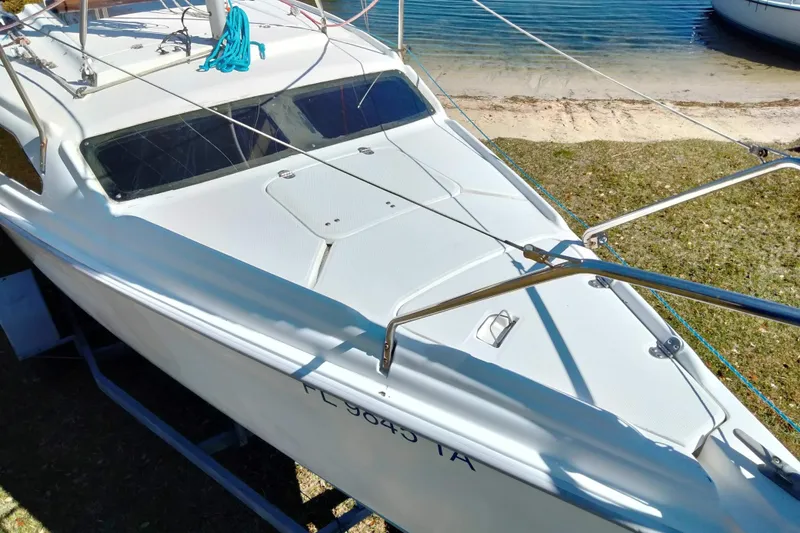 Slide: The Image of Sailboat Hunter 240, 1998 model, docked on shore with visible rigging and deck. - 15