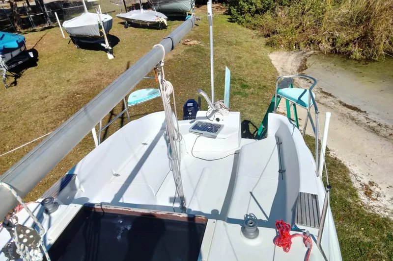 Slide: The Image of 1998 Hunter 240 sailboat on grassy shore, mast down, surrounded by other boats. - 27