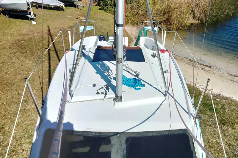 Slide: The Image of Sailboat Hunter 240, 1998 model, docked on grassy shore near water. - 28