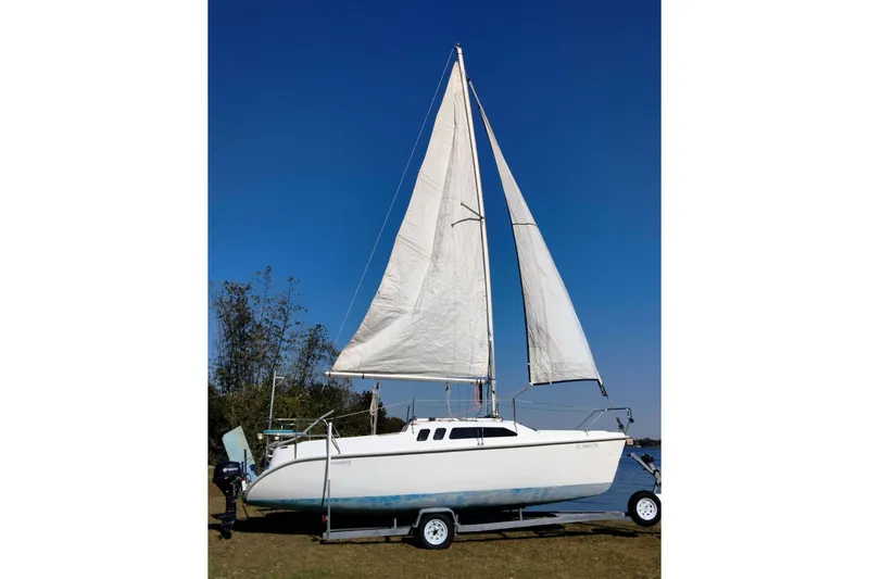 Slide: The Image of 1998 Hunter 240 sailboat on trailer with sails raised, set against a clear blue sky. - 30
