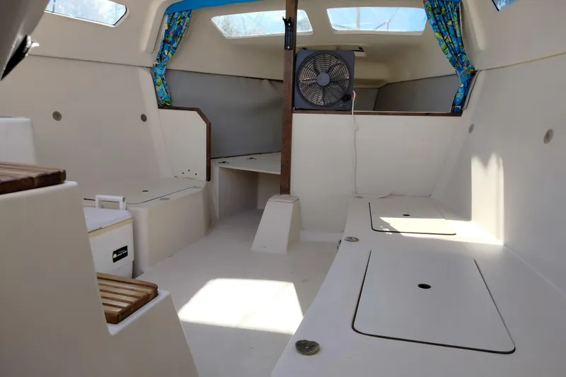 Slide: The Image of Interior of a 1998 Hunter 240 sailboat with seating and a fan. - 9