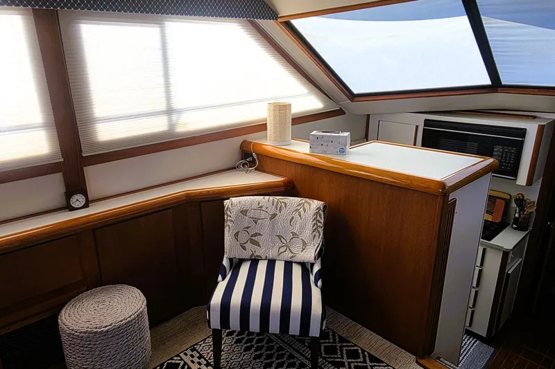 Slide: The Image of Interior of 1990 Californian 48 Cockpit Motor Yacht with striped chair and modern amenities. - 16