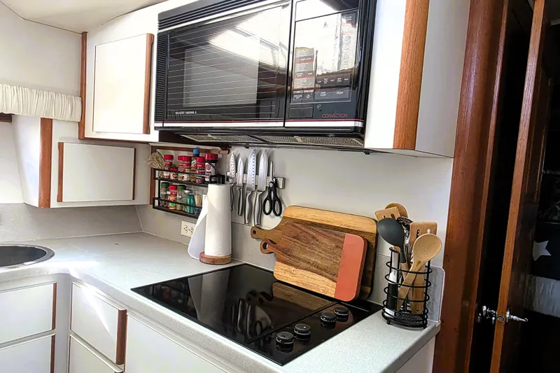 Slide: The Image of Compact kitchen in a 1990 Californian 48 Cockpit Motor Yacht with modern appliances. - 20