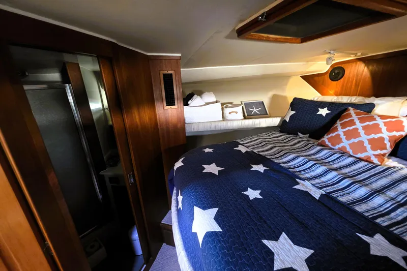 Slide: The Image of Cozy bedroom in 1990 Californian 48 Cockpit Motor Yacht with star-themed bedding. - 24