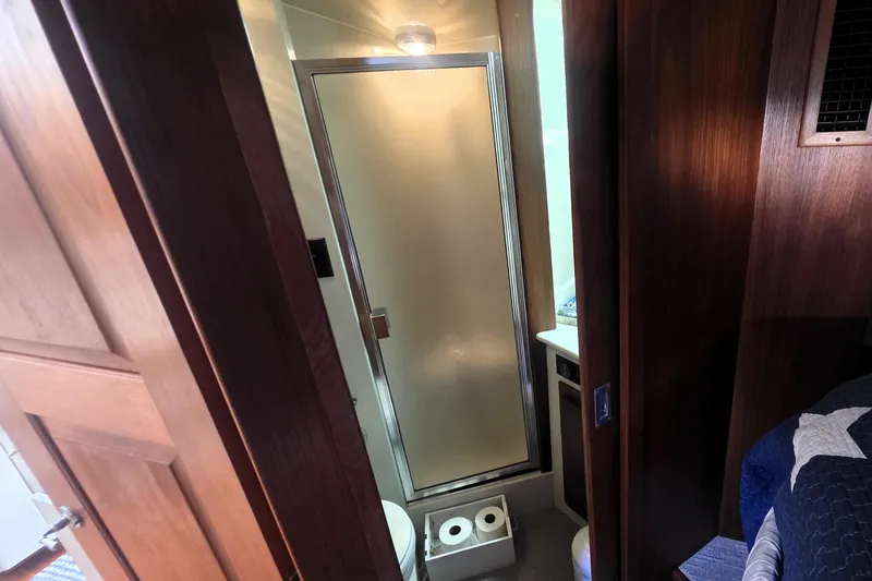 Slide: The Image of Bathroom interior of 1990 Californian 48 Cockpit Motor Yacht with shower and wooden accents. - 26
