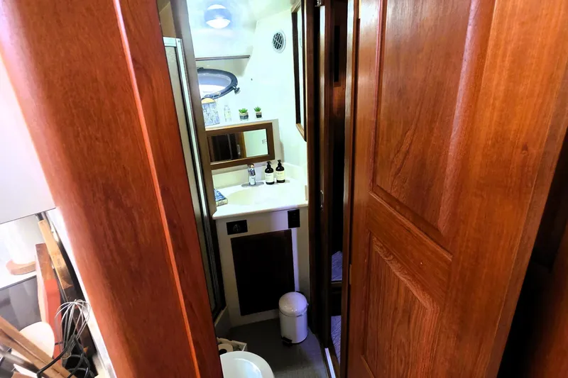 Slide: The Image of 1990 Californian 48 Cockpit Motor Yacht interior with wooden cabinetry and compact bathroom. - 29