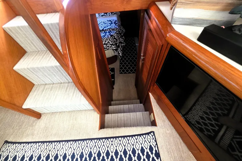 Slide: The Image of Interior of 1990 Californian 48 Cockpit Motor Yacht with wooden stairs and patterned carpet. - 30