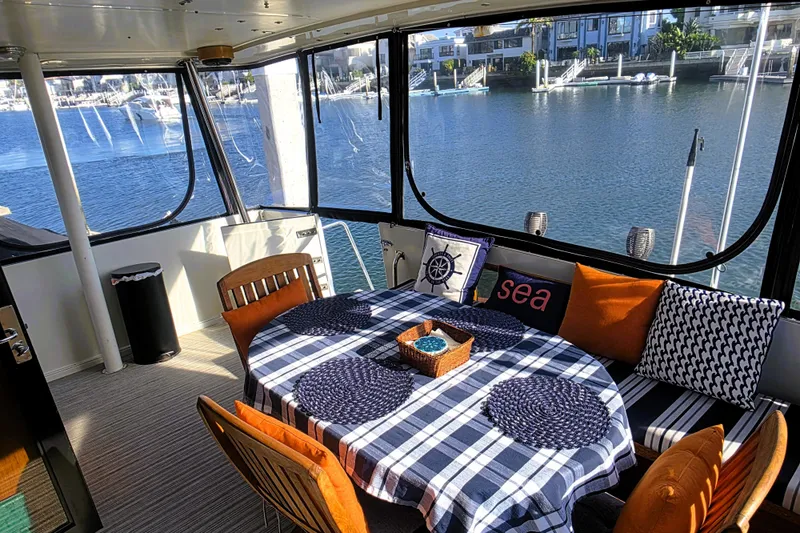Slide: The Image of Cozy dining area on 1990 Californian 48 Cockpit Motor Yacht with waterfront view. - 59