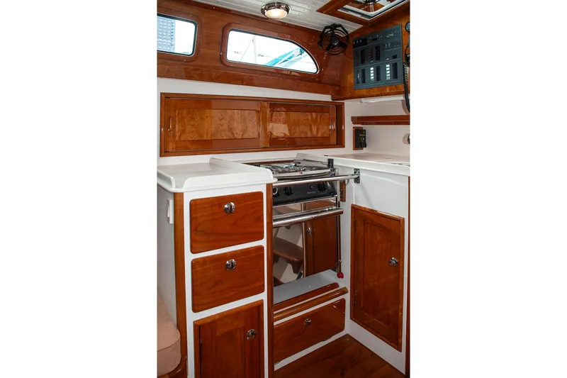 Slide: The Image of Interior of 2011 Morris M42 yacht featuring a compact wooden galley with stove and storage. - 20