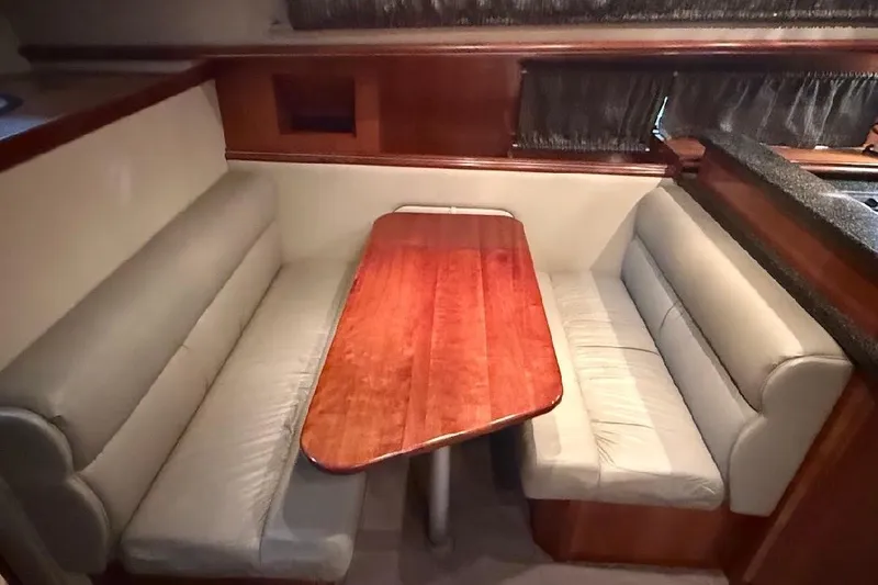 Slide: The Image of Luxurious dining area in 2005 Cruisers Yachts 405 Express Motoryacht with plush seating and wooden table. - 27