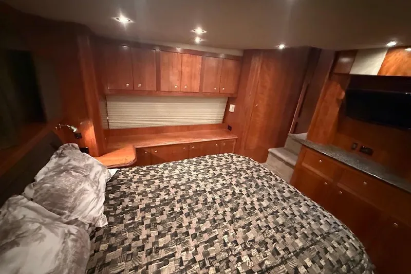 Slide: The Image of Luxurious 2005 Cruisers Yachts 405 Express Motoryacht bedroom with wood cabinetry and cozy bedding. - 31