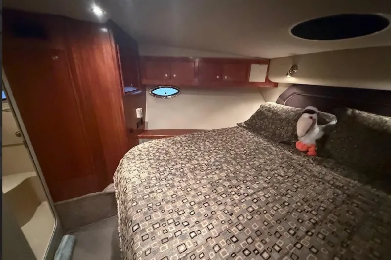 Slide: The Image of Luxurious bedroom in 2005 Cruisers Yachts 405 Express Motoryacht with plush bedding and wooden cabinetry. - 52