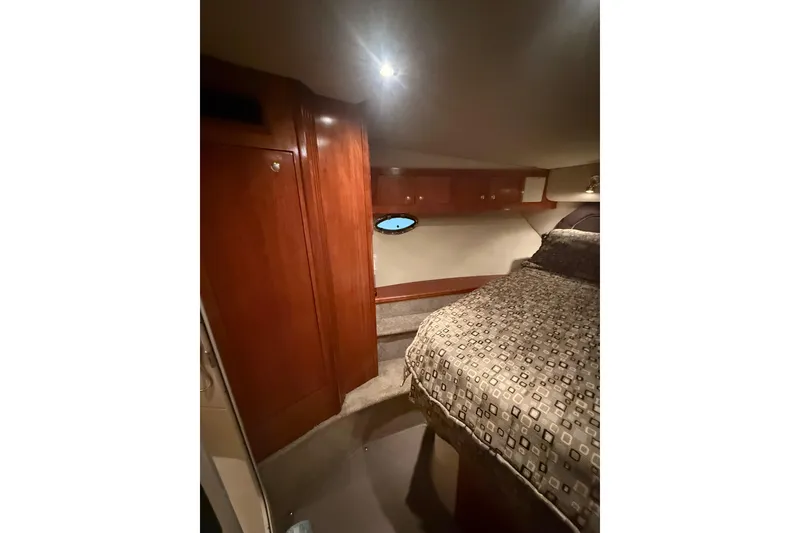 Slide: The Image of 2005 Cruisers Yachts 405 Express Motoryacht cabin interior with wood paneling and bed. - 53