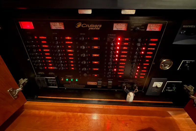Slide: The Image of Electrical control panel of 2005 Cruisers Yachts 405 Express Motoryacht, illuminated with red lights. - 59