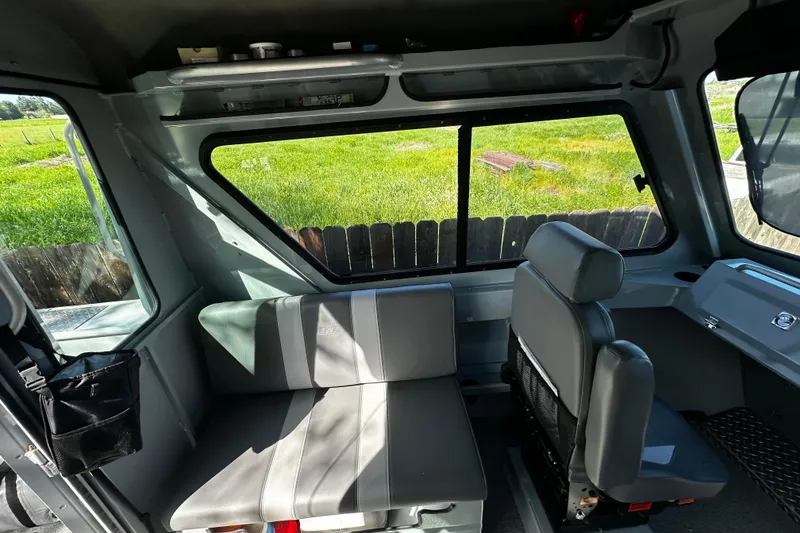 Slide: The Image of Interior of 2022 Hewescraft 220 Ocean Pro ET Hardtop, featuring seating and windows. - 10