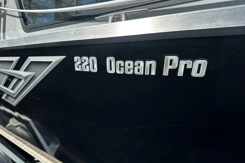 Slide: The Image of 2022 Hewescraft 220 Ocean Pro ET Hardtop boat logo on black hull. - 12