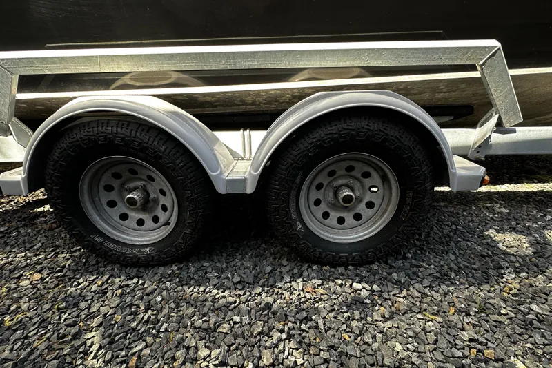 Slide: The Image of Trailer wheels of a 2022 Hewescraft 220 Ocean Pro ET Hardtop on gravel. - 27