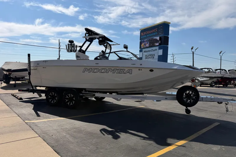 Slide: The Image of 2025 Moomba Makai boat on trailer at dealership under clear sky. - 10