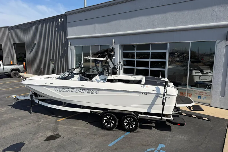 Slide: The Image of 2025 Moomba Makai boat on trailer outside dealership, showcasing sleek design and modern features. - 2