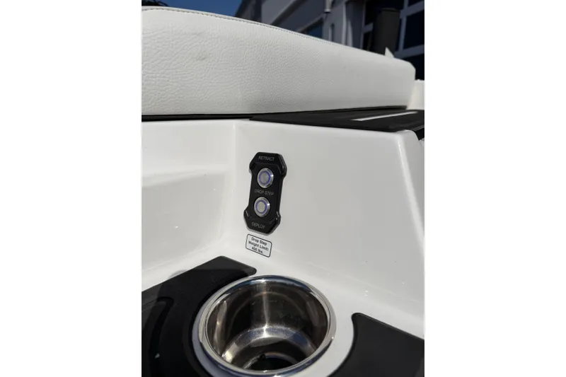 Slide: The Image of 2025 Moomba Makai boat interior with retractable step controls and cup holder. - 7