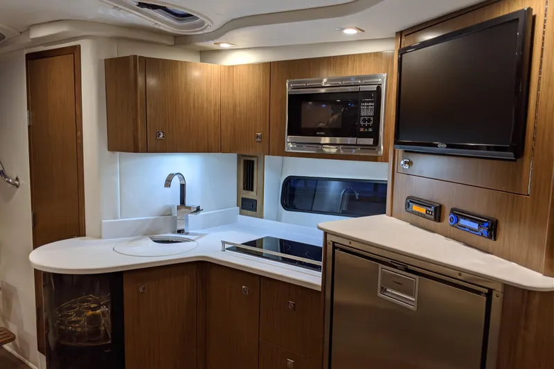 Slide: The Image of Luxurious 2019 Cruisers Yachts 38 Express kitchen with modern appliances and sleek wood cabinetry. - 11