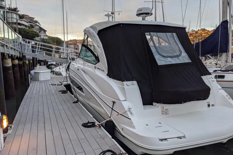 Slide: The Image of 2019 Cruisers Yachts 38 Express docked at marina, covered with black canvas. - 16