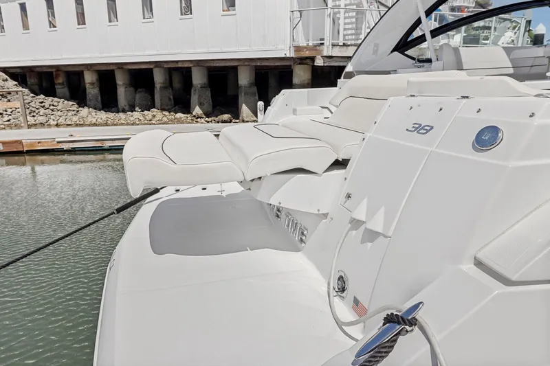 Slide: The Image of 2019 Cruisers Yachts 38 Express at dock, featuring sleek white design and comfortable seating. - 32