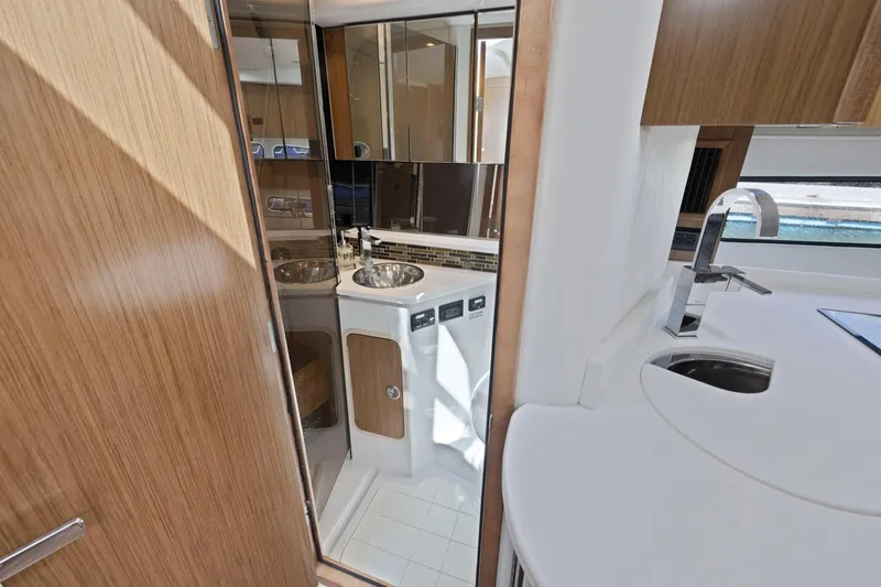 Slide: The Image of 2019 Cruisers Yachts 38 Express interior with modern bathroom and kitchenette design. - 42