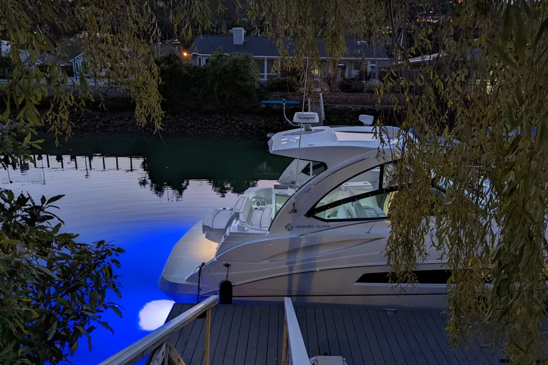 Slide: The Image of 2019 Cruisers Yachts 38 Express docked at twilight with blue underwater lights. - 5