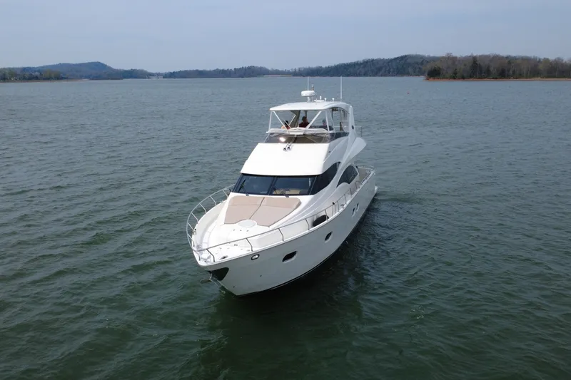 Slide: The Image of Luxurious 2004 Marquis 59 yacht cruising on a serene lake with scenic background. - 12