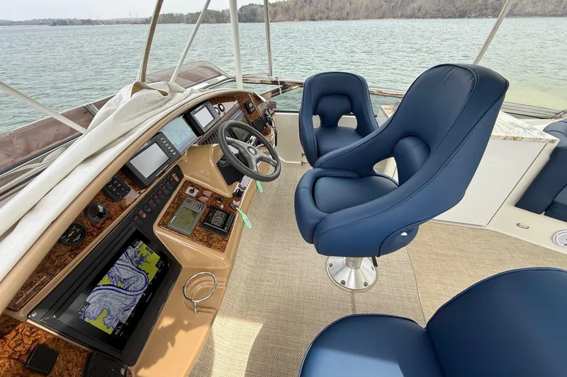 Slide: The Image of Luxurious 2004 Marquis 59 yacht helm with blue captain chairs and advanced navigation systems. - 13