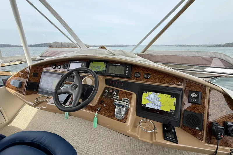Slide: The Image of Luxurious 2004 Marquis 59 yacht helm with advanced navigation systems and scenic water view. - 14