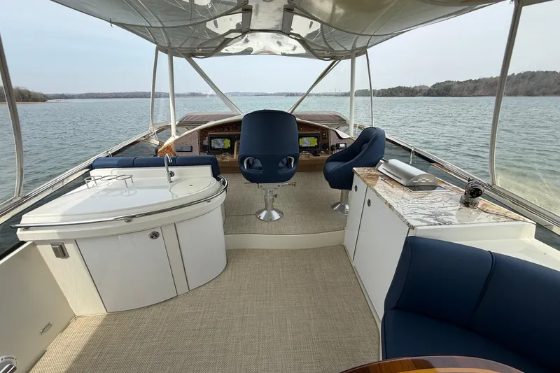 Slide: The Image of Luxurious 2004 Marquis 59 yacht interior with elegant seating and navigation area on a serene lake. - 19