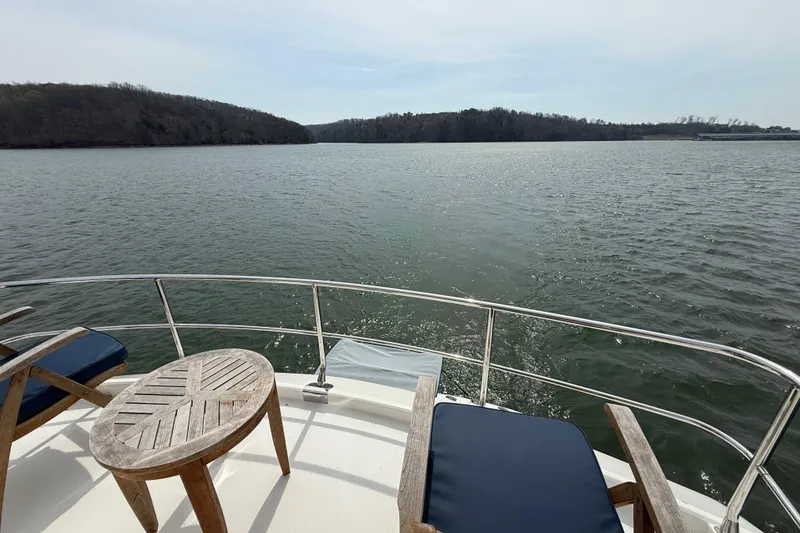 Slide: The Image of Luxury yacht deck view on water, featuring wooden chairs and table, Marquis 59, 2004 model. - 22
