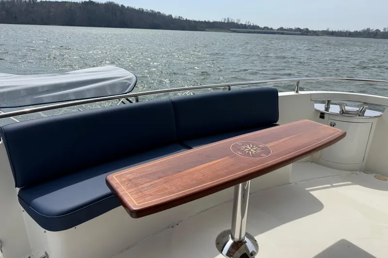 Slide: The Image of Luxury seating area on a 2004 Marquis 59 yacht with a wooden table. - 24