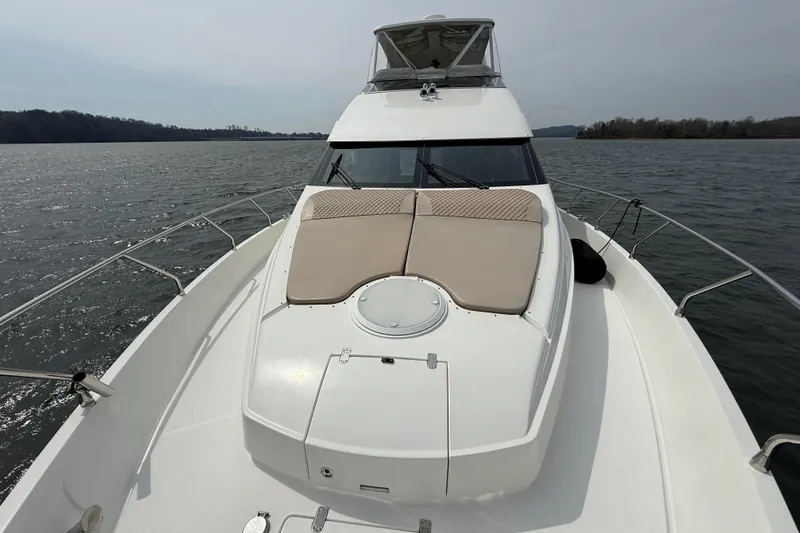 Slide: The Image of 2004 Marquis 59 yacht on calm waters, featuring spacious deck and sleek design. - 25