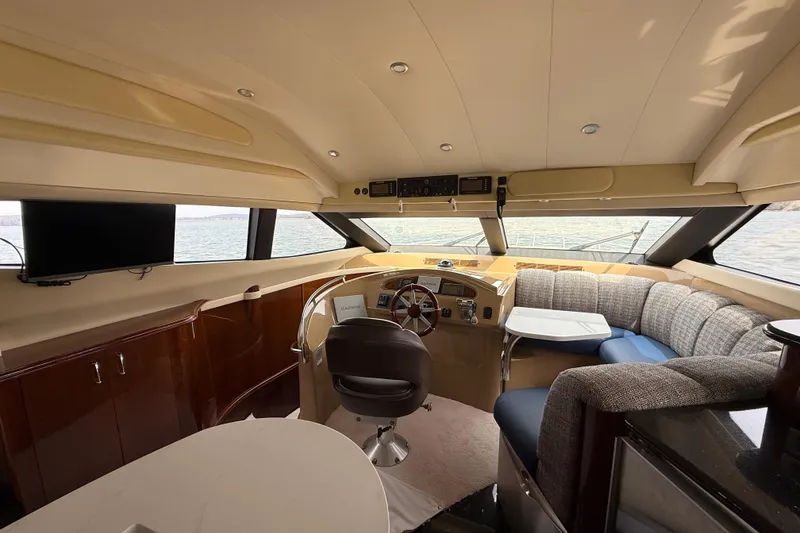 Slide: The Image of Luxurious interior of a 2004 Marquis 59 yacht with helm, seating, and panoramic windows. - 29