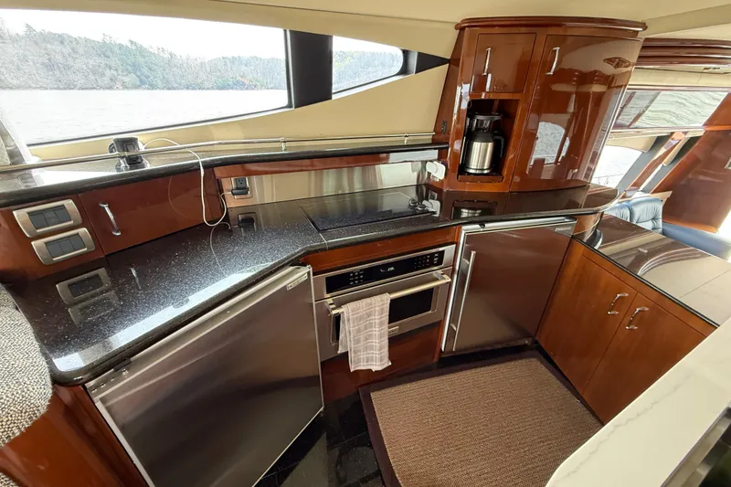 Slide: The Image of Luxurious 2004 Marquis 59 yacht kitchen with modern appliances and sleek wood cabinetry. - 30