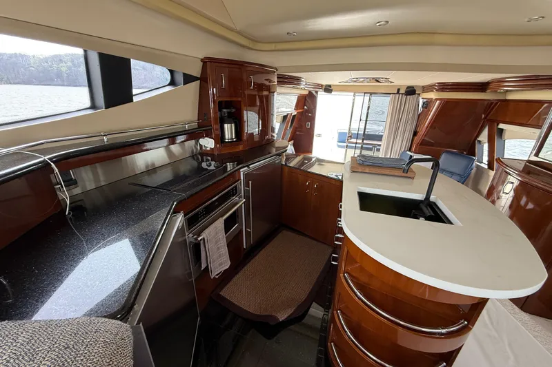 Slide: The Image of Luxurious interior of a 2004 Marquis 59 yacht featuring a modern kitchen with sleek countertops. - 31