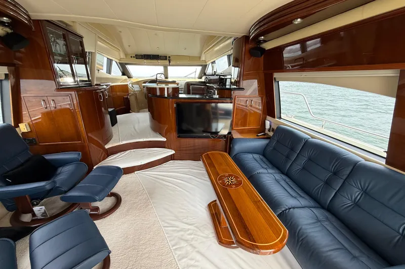 Slide: The Image of Luxurious interior of a 2004 Marquis 59 yacht with elegant wood finishes and blue seating. - 34
