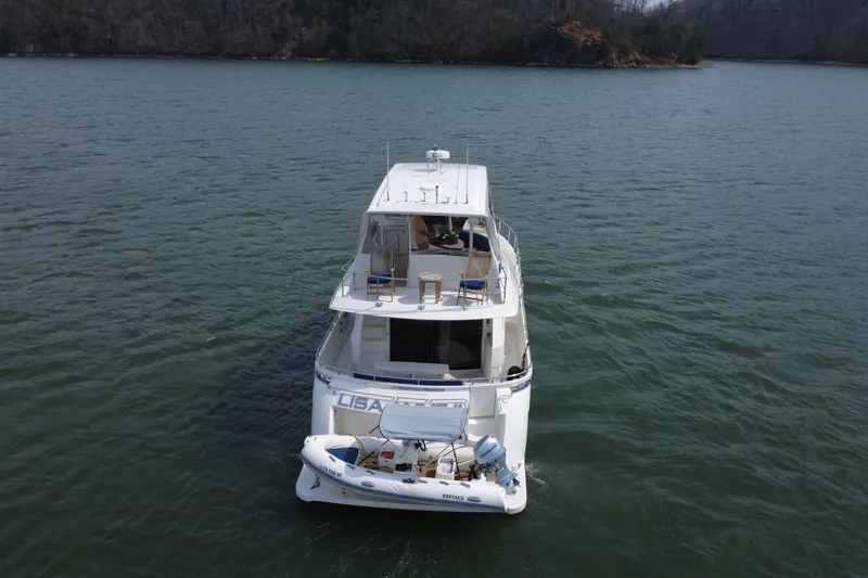 Slide: The Image of 2004 Marquis 59 yacht on a serene lake, viewed from the rear. - 4