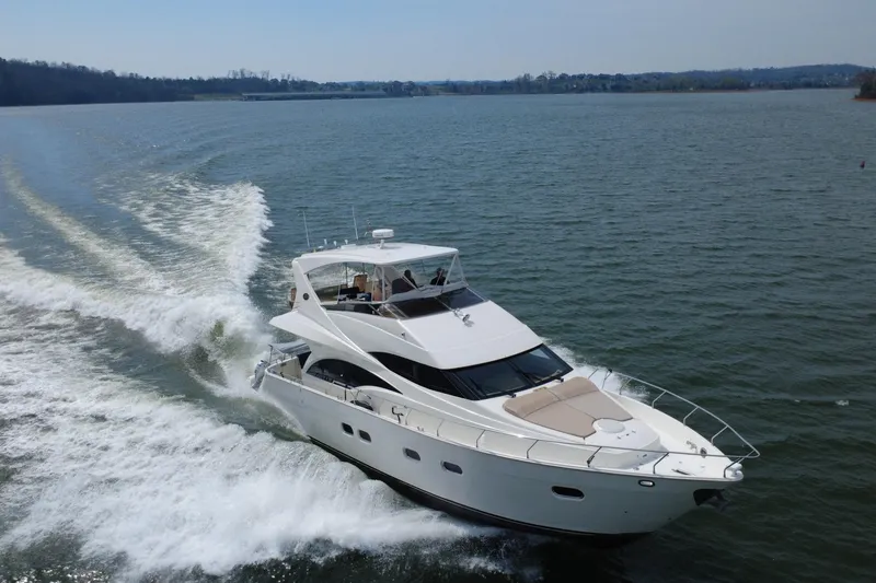 Slide: The Image of Luxurious 2004 Marquis 59 yacht cruising on a serene lake under clear skies. - 6