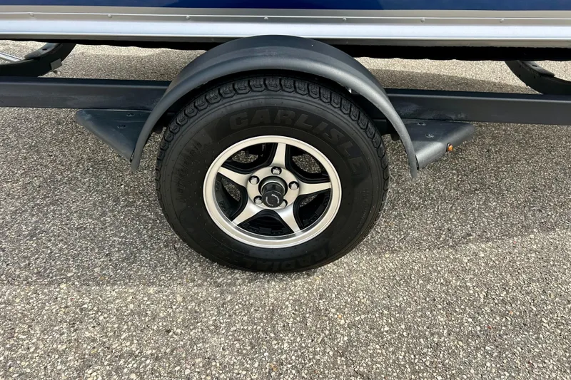 Slide: The Image of Trailer wheel of 2021 Alumacraft Classic 165 Sport on asphalt surface. - 11