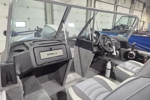 Slide: The Image of 2021 Alumacraft Classic 165 Sport boat interior with steering wheel and seating. - 4