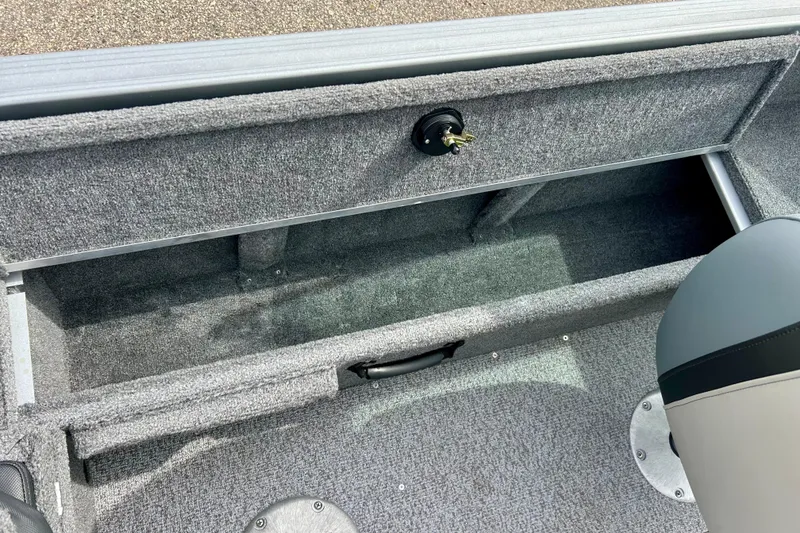 Slide: The Image of 2021 Alumacraft Classic 165 Sport boat storage compartment with gray carpet interior. - 44