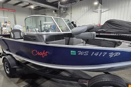 Slide: The Image of 2021 Alumacraft Classic 165 Sport boat in a garage setting. - 5