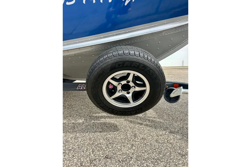 Slide: The Image of 2021 Alumacraft Classic 165 Sport trailer tire on pavement. - 59