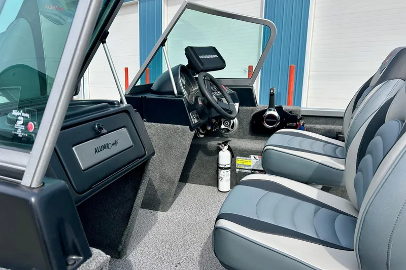Slide: The Image of 2021 Alumacraft Classic 165 Sport boat interior with steering wheel and seating. - 63