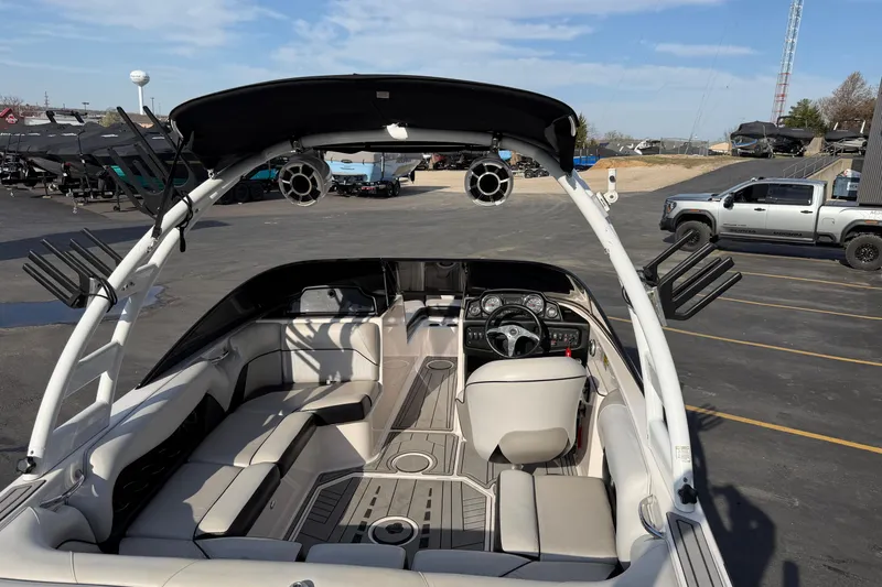 Slide: The Image of 2014 Moomba Mondo boat interior with seating and steering wheel, parked in a lot. - 11