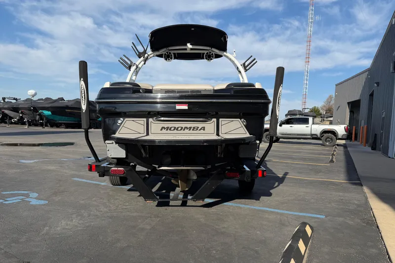 Slide: The Image of 2014 Moomba Mondo boat parked outdoors, showcasing rear view and trailer setup. - 5